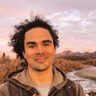 Portrait of Tyler Bonnen smirking outdoors