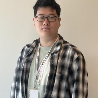 Fen posing for camera in a plaid shirt