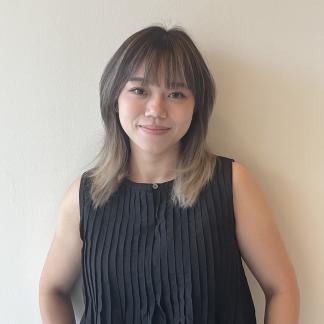 Mia smiling at camera in a black top